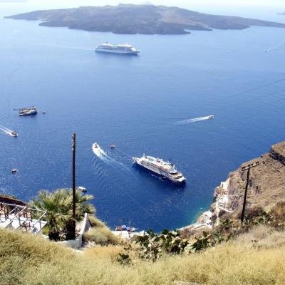 View from Fira down to the harbor and cruise ships and the volcanic island Nea Kameni in the background