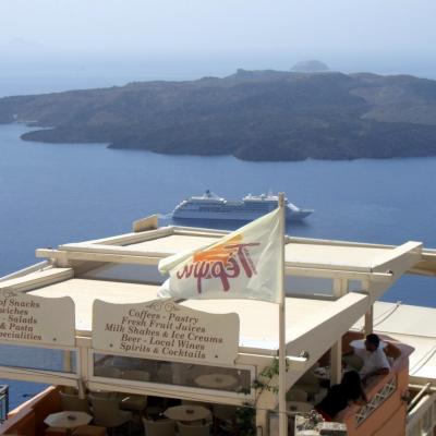 Cafe with view of cruise ship and island Nea Kameni